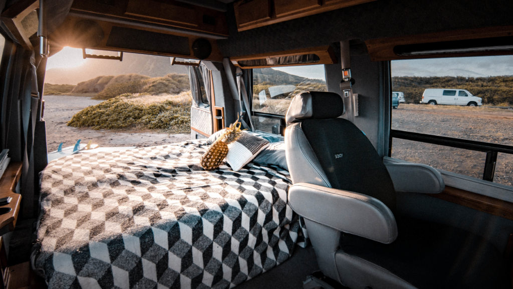 Pineapple on bed of campervan at the beach in hawaii